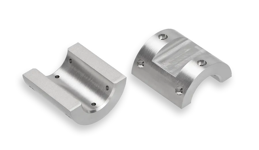 Zwei Halbschalen gefertigt nach Zeichnung aus Wolfram-Schwermetall (WSM) dienen als Innenmasse in der Anwendung.