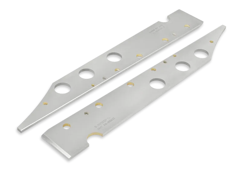 Zwei Leisten aus Hartmetall (HM) mit Spuren von der zuvor erfolgten Erodierung. Die Leisten sind aufwendig geschliffen und haben hochpräzise Winkel und Symmetrien. Eine Gravur mit der Seriennummer bzw. der NHT Auftragsnummer ist auf dem Teil aufgebracht.