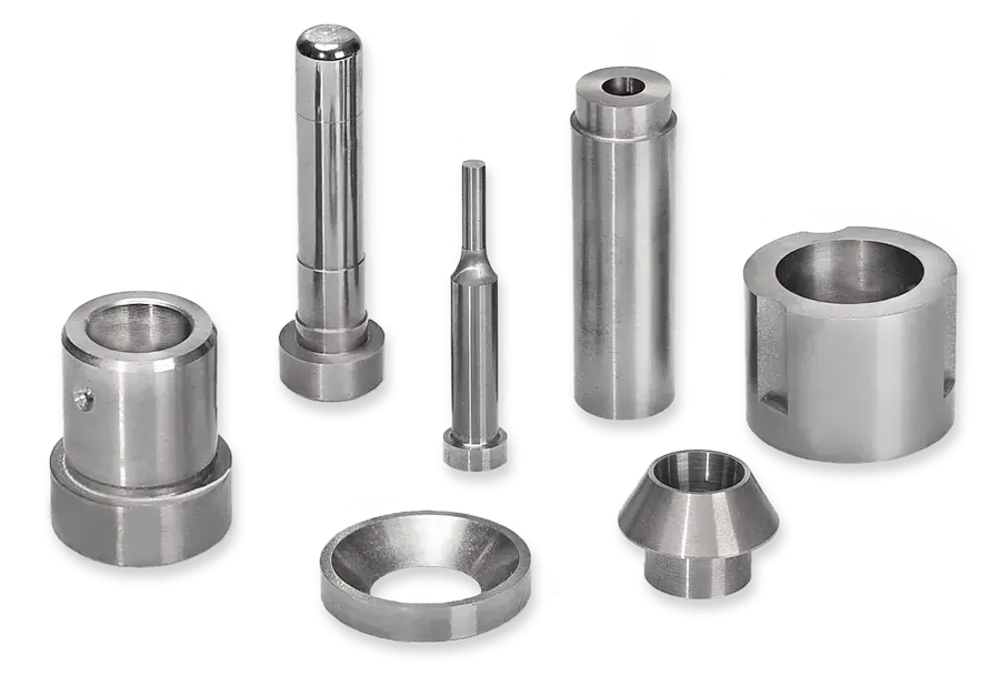 Sieben präzisionsgefertigte Metallteile aus Hartmetall (HM) für Schnitt- und Stanzwerkzeuge nach Zeichnung gefertigt. Unterschiedlicher Form und Größe, darunter zylindrische Stangen, Ringe.